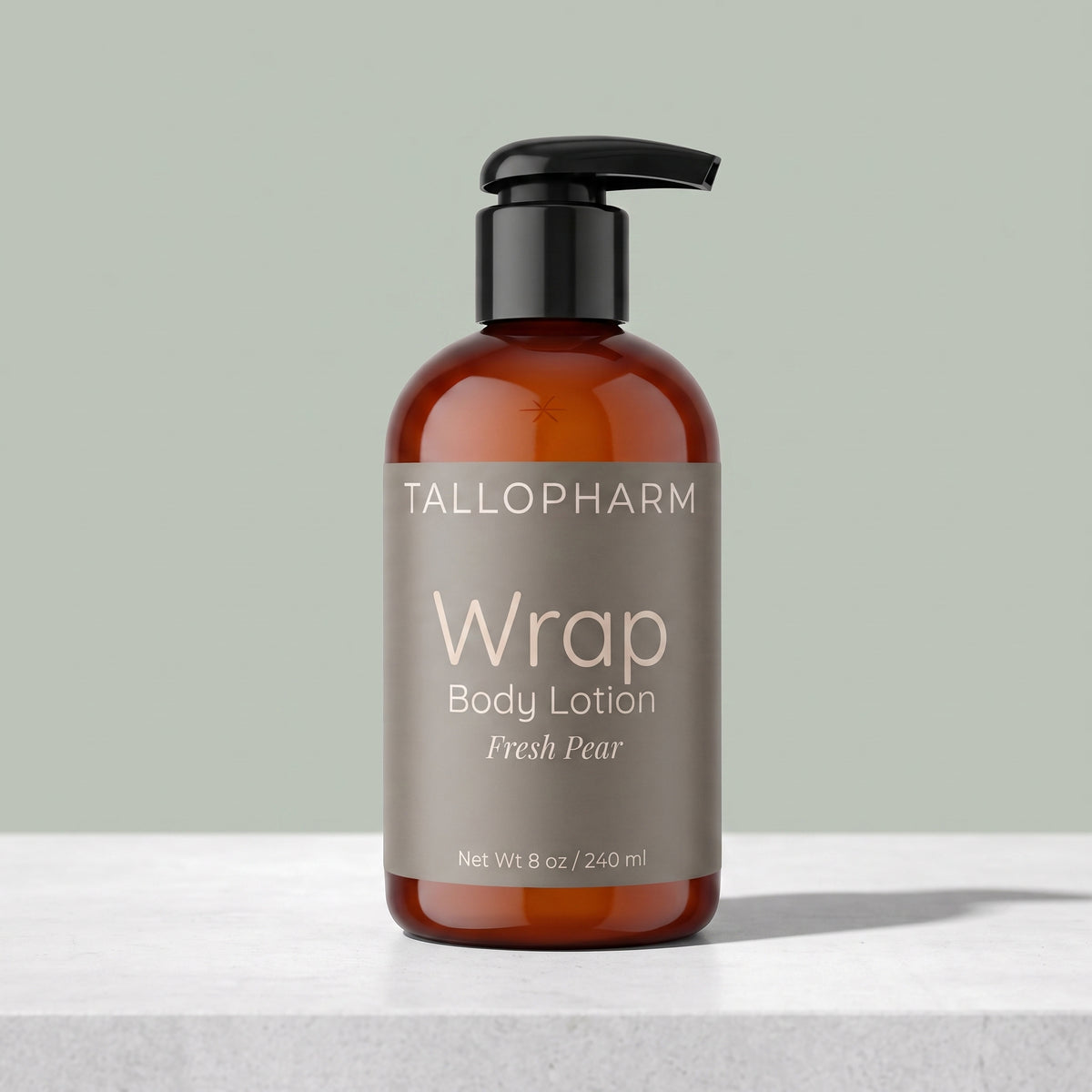 An amber glass pump bottle of Tallopharm Wrap Body Lotion in Fresh Pear, set on a light gray surface against a muted sage green background. Fresh Pear fragrance.
