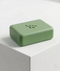 Green soap bar with a leaf design on a gray surface