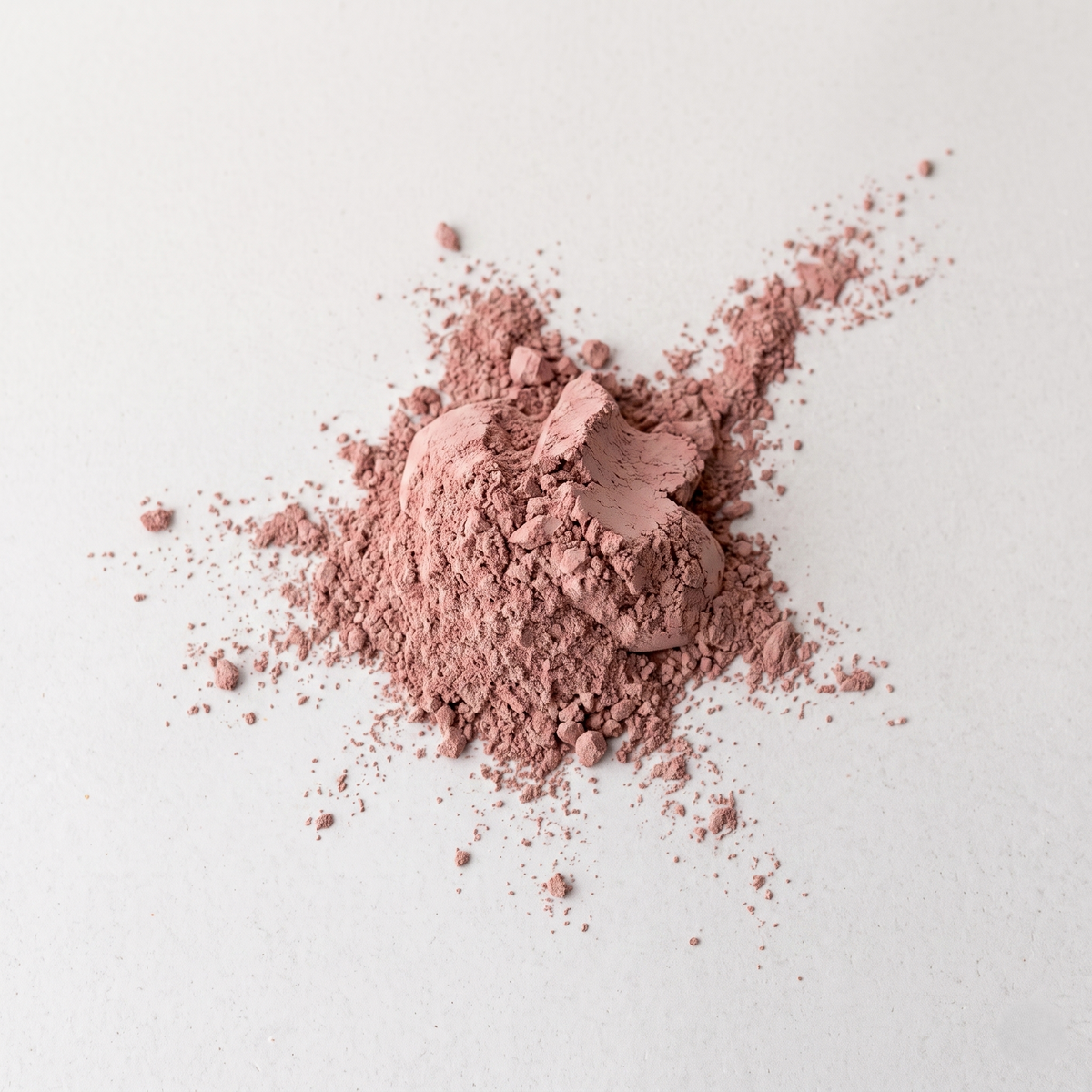 Pink clay powder on a light gray background