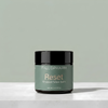 A jar of Tallopharm Reset Whipped Tallow Balm sits on a white concrete surface against a sage green background.