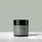 A jar of Tallopharm Reset Whipped Tallow Balm sits on a white concrete surface against a sage green background.