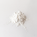 White non-nano zinc oxide powder on a light gray background